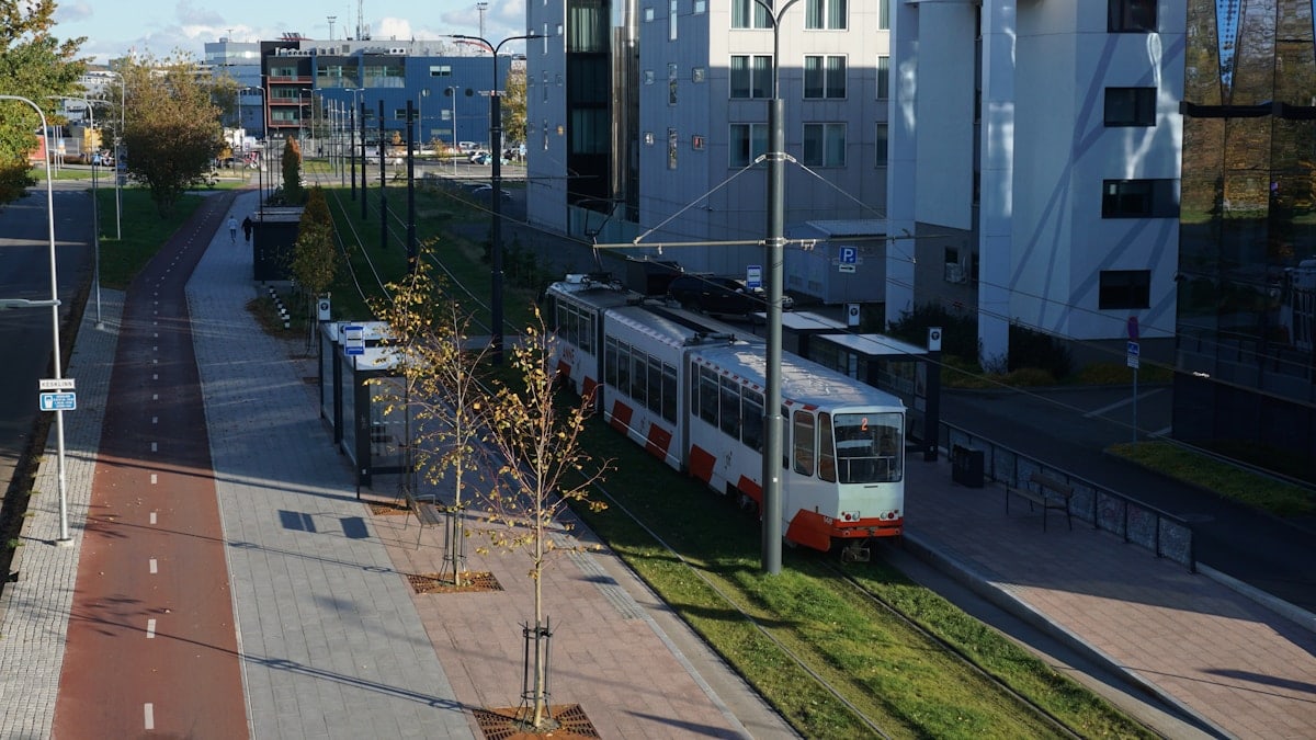 Modern tram on tracks in a city street.